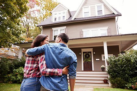 Adoptive couple in front of home awaiting home study
