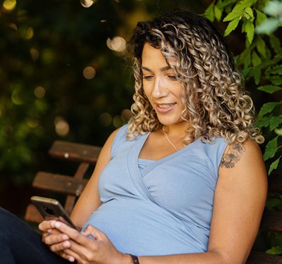pregnant woman on bench on phone